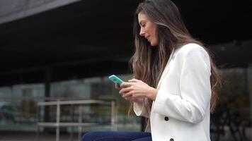 A Professional Woman Actively Engaged with Her Smartphone While Enjoying the Outdoors video