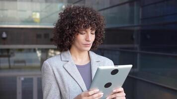 A Professional Woman Engaged in Using a Tablet While in a Modern Urban Environment video
