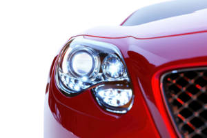 A close-up of a sleek red car's headlight, showcasing its modern design and glossy finish against a transparent background. png