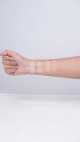 A hand with several shades of compact powder or foundation swatched on the skin. video