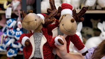 stuffed deer toys on the store shelf. Christmas trees toys, and festive decorations are on display on a store shelf. video