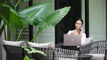 A psychologist coach in glasses gives an online consultation in a modern office with panoramic windows. Networking and discussion, exchange of ideas at a conference. Working with a client online video
