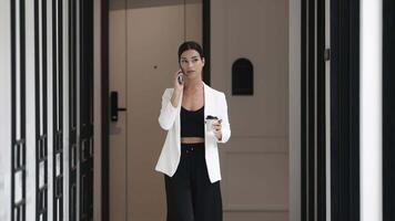 Businesswoman talking on phone during coffee break in modern office with panoramic windows. networking and discussion, share ideas at conference. Digital marketing and brainstorming. video