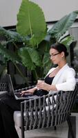 Businesswoman using a laptop, computer analyzing stock exchange market crypto trading decreasing chart data fall down loss, desperate about losing money of crisis, recession, inflation. Vertical shot video