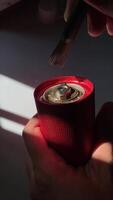 A close-up image of a person cleaning a red coffee grinder with a brush. The image highlights the details of the grinder's mechanism and the cleaning process. video