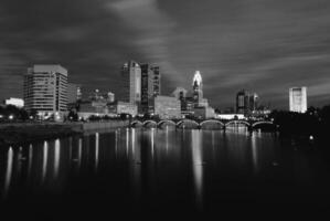 Serene Dusk Reflection of Skyscrapers on a Tranquil Lake Under a Cloudy Sky photo
