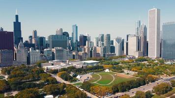 Chicago skyline with Millennium Park aerial view. Aerial view of Chicago's skyline featuring Millennium Park and surrounding high-rise buildings on a clear, sunny day in autumn. video