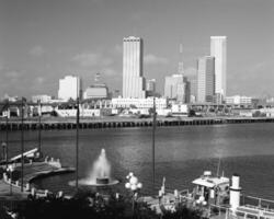 Skyline Reflections Modern Skyscrapers and Boating Scenes Under a Bright Daytime Sky photo