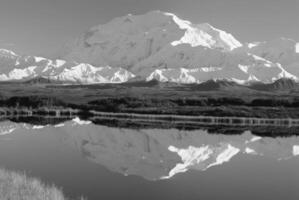 Majestic Highland Landscape Snow-Capped Mountains and Tranquil Waters Under a Blue Sky photo