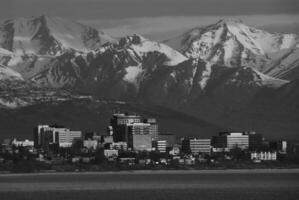Majestic Highland Scenery Snow-Capped Mountains Reflecting in Tranquil Waters Under a Cloudy Sky photo
