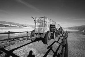 Rustic Highland Landscape with Automotive Tire and Wooden Fence under a Cloudy Sky photo