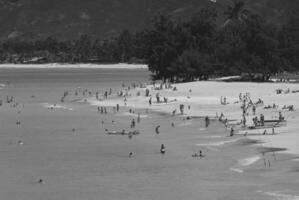 Relaxing Day at the Beach People Enjoying the Sun and Sea Amidst Coastal Scenery photo
