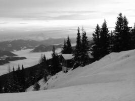 Snowy Mountain Landscape with Trees and Clouds in the Sky photo