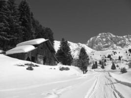 Snowy Mountain Landscape with House and Trees Visible Through Window photo