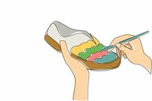 A person is painting a shoe with a brush vector