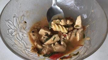 A close-up shot of a creamy chicken pasta dish served in a glass bowl. The pasta is coated in a rich, creamy sauce and topped with tender chunks of chicken. video