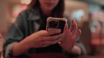 Coffee Break Connection. A young woman engrossed in her phone, enjoying a moment of peace and connection over a cup of coffee in a trendy cafe setting. video