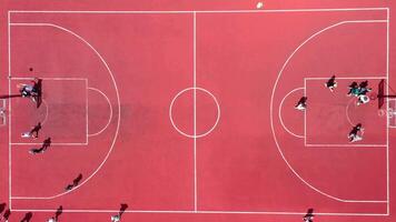 Aerial view of young athletes playing street basketball on an open summer playground. video
