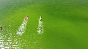 Aerial view of the rowboats with teams of strong people starting along the water surface. video