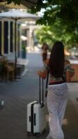 A woman with a suitcase stands in a city, embracing adventure while awaiting her journey video