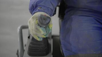 A worker is skillfully operating heavy machinery controls in an industrial setting. Clip video