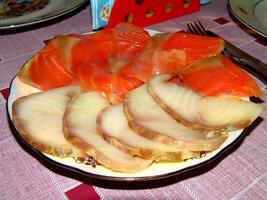 Red and white fish slices on a plate close view background photo