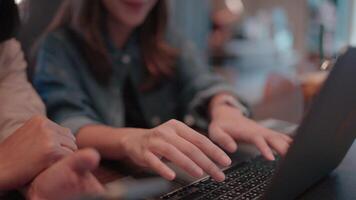 Cafe Collaboration. Close-up shot of two hands actively typing on a laptop in a cozy cafe setting, suggesting teamwork, brainstorming, or project collaboration. video