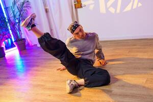 A dancer practices a move on the floor of a dance studio photo