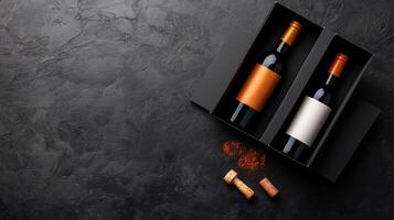 Two elegant wine bottles in a black gift box on a textured surface with corks and spices nearby photo