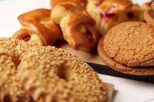 Baked goods display with various pastries and cookies on a wooden platter at a cozy cafe setting photo