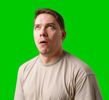 Man making a humorous expression against a bright green background photo