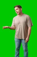 Man with a confused expression gestures with his hands against a bright green background photo