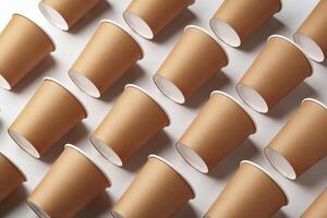 A collection of disposable paper cups arranged in a repeating pattern on a light background photo