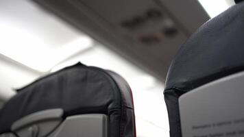 An unrecognizable man walks along the seats on the plane. The interior of the aircraft cabin, free comfortable economy class seats. video