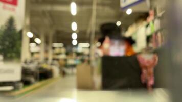 Blurred background when walking through the supermarket. Blurred background of a supermarket interior with shelves from up to the ceiling. Hall or mall with blurred lights background video