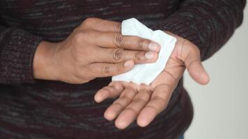 man disinfecting his hands with a wet wipe. video