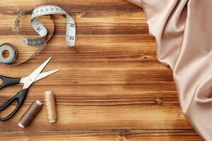 Crafting tools and materials arranged on a wooden table for sewing projects photo
