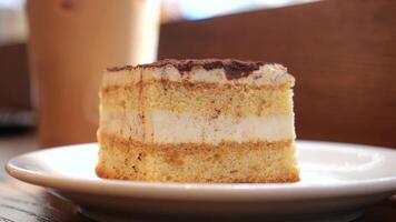 A layered cake with cream and rich chocolate topping that delights video