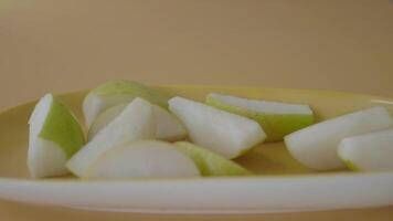 Sliced Green Pears on a Yellow Plate Against a Simple Background video