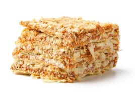 Sweet pastry layers filled with creamy filling from a bakery display on a white background photo