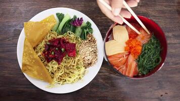 Top view of a person using chopsticks to eat asian bowl with noodles. Poke bowl with salmon, rice, avocado, wakame salad. Japanese noodles, Ramen with Beef or chicken, Tom Yam kung Spicy Thai video