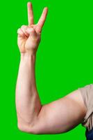 A strong arm making a peace sign against a vibrant green background photo
