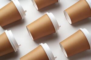 A collection of disposable paper cups arranged in a repeating pattern on a light background photo