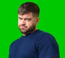 Man expressing confusion with crossed arms in front of a bright green background photo