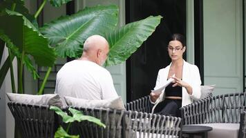 Two business colleagues having a meeting outdoors at a cafe. Startup, business meeting discussing, brainstorming, and analyzing data. Collaboration and planning for new strategies, ideas video