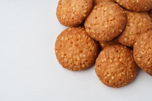 Crispy golden cookies stacked on a white surface, inviting a sweet moment of indulgence photo