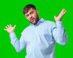 A man playfully posing with a quirky expression against a bright green background photo