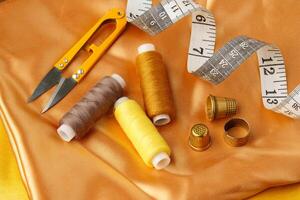 Sewing tools and materials arranged on a luxurious golden fabric background in a creative crafting workspace photo