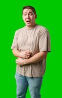 Man expressing fear while standing against a bright green background photo