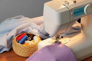 Sewing machine in use on a wooden table, stitching a light fabric in a well-lit indoor workspace photo